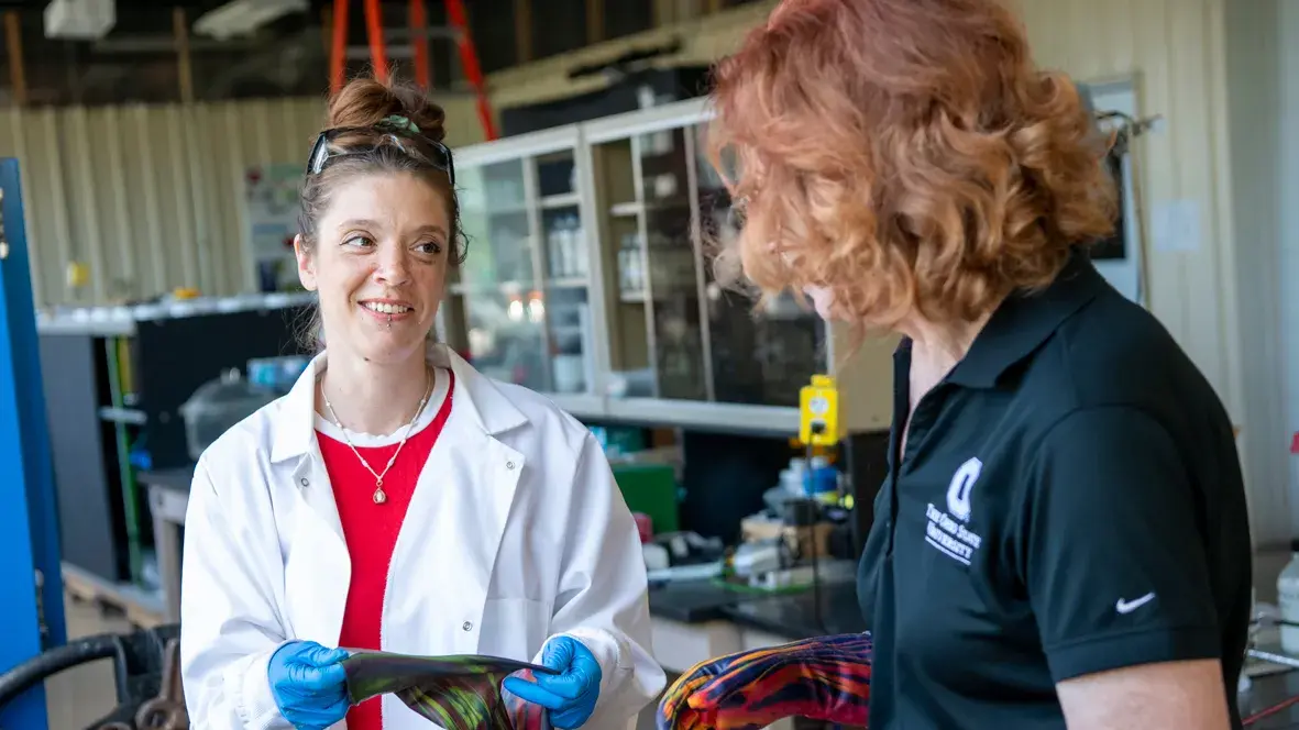 two researchers putting on colored latex gloves before doing quality check procedures