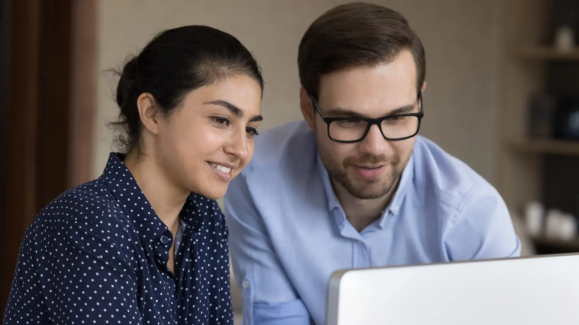 Two people looking at a laptop